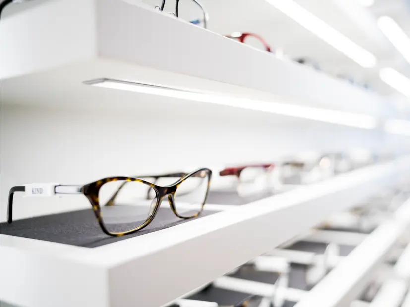 Nahaufnahme eines beleuchteten Brillenregals in der Filiale Götting – moderne LED-Beleuchtung für optische Warenpräsentation