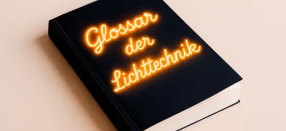 Buch mit leuchtenden Buchstaben, das symbolisch das „Glossar der Lichttechnik“ darstellt.