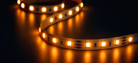 Leuchtendes LED-Band auf schwarzem, glänzendem Untergrund.